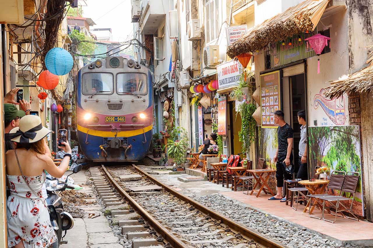 Experience the vibrant energy of Hanoi in a unique way - by taking a walk down its iconic train street - vietnam tourist sites