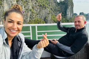 Tourists relaxing on a cruise boat while admiring limestone islands in Halong Bay Vietnam