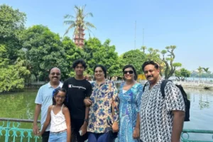 Tourist family posing for a photo at Tran Quoc Pagoda by West Lake in Hanoi Vietnam