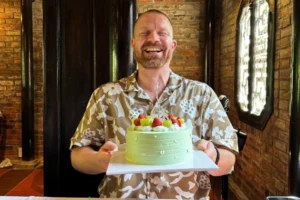 Traveler celebrating a birthday with a cake during a Vietnam tour organized by Sao La Vietnam Tours