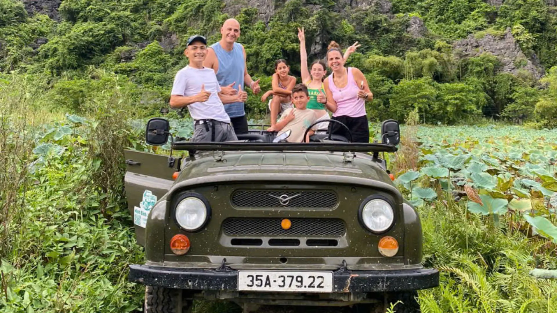Tourists standing on a UAZ jeep during a countryside tour in Ninh Binh Vietnam